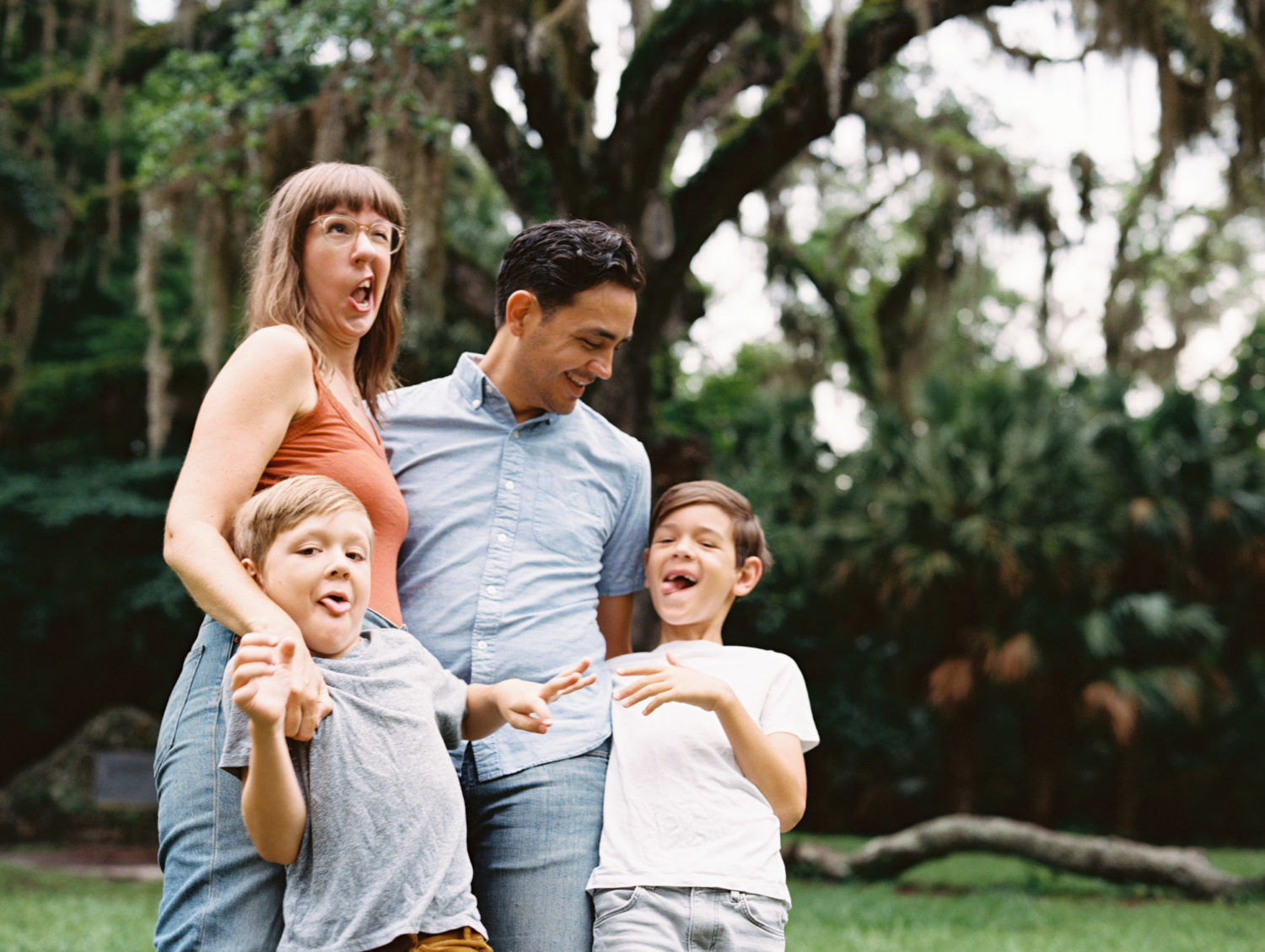 family of four making silly faces and laughing during their outdoor family photoshoot